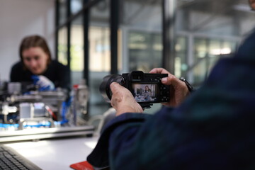 engineer using a camera to take photos of  a motherboard prototype  robot in the training class