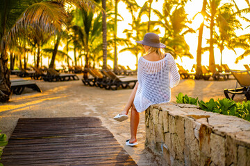 Woman on sunny, tropical beach at daybreak
