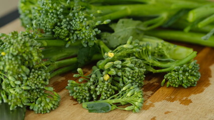 Fresh Broccolini vegetables on a cutting board.