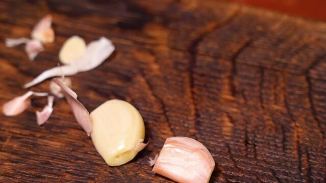 Close-up of male hands at home kitchen clean garlic from the peel	
