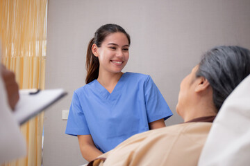Young caregiver or nurse care and talking patient elderly on bed for consoling in room at hospital...