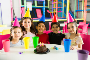 Excited children smiling at a birthday party waiting for cake