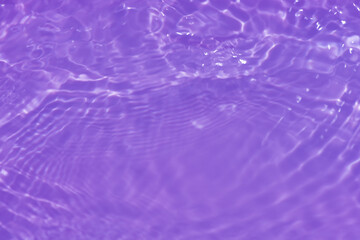 Fototapeta na wymiar Purple water with ripples on the surface. Defocus blurred transparent pink colored clear calm water surface texture with splashes and bubbles. Water waves with shining pattern texture background.