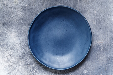 Empty blue plate on old plaster background