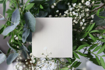 a blank card on top of a bridal flower bouquet