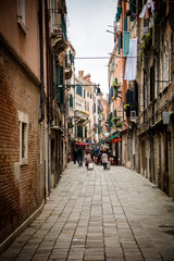 Photo of people strolling down a charming narrow street in Venice, Italy