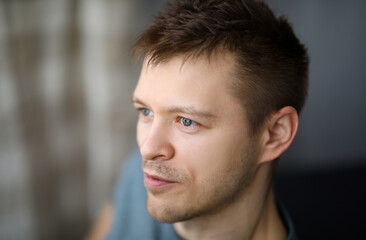 Obraz premium Close-up portrait in profile of an ordinary guy. Appearance young man. Man looks into distance. Calm and satisfaction with life. Positive emotions from loneliness during self-isolation