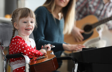 Baby learns play musical instruments with parents. Music teaches to think and live in several...