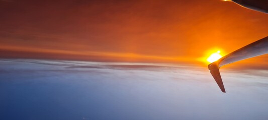 Coucher de soleil orangé sur le bout de l'aile de l'avion