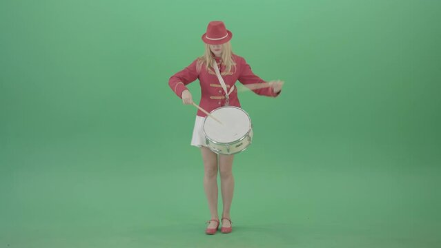 Girl in red dress marching and playing drum snare music instrument over green screen - 4K Video Footage