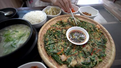 Pajeon Korean seafood pancake and beef bone soup eating chopsticks with rice and side dishes food