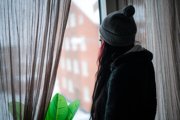 Young woman looking out trough window