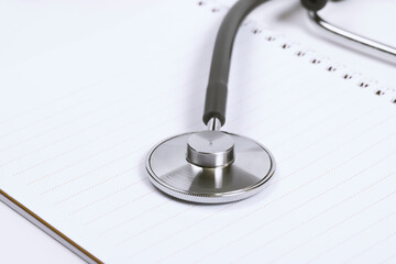 Doctor desk.Stethoscope and notebook on white background