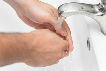 man washes his hands in the bathroom.The best protection against corona virus infection.Corona Virus pandemic protection by cleaning hands frequently.