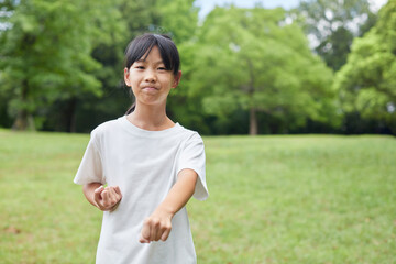 真夏の公園で空手を練習している小学生の女の子の様子