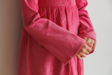 Little girl with blond long hair in two pigtails in new clothes for product demonstration sale in the store