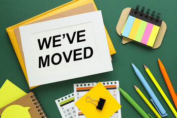 We've Moved text on white paper in a frame on a green background