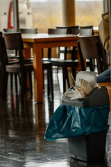 gefüllter Kunststoff Mülleimer mit Einweggeschirr in Gaststätte