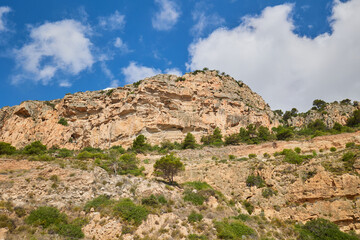 Fototapeta na wymiar A rock against a blue sky. Near the beach Cala del Moraig, Spain. For alpinism