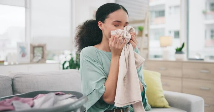 Laundry, fabric and a woman smelling a scarf in her home while spring cleaning in her home for hygiene. Fresh, material or aroma with a happy young person in an apartment for housework or chores