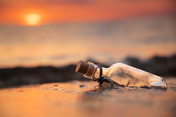 Message in the bottle against the Sun setting down - 636991951