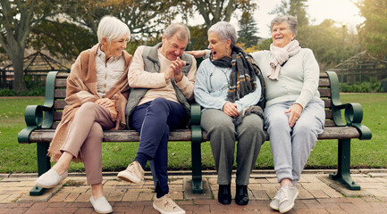 Conversation, bonding and senior friends in a park sitting on bench for fresh air together. Happy,...