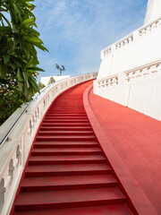 A nicely curved, intensely red staircase leading up to the top of Wat Saket, Golden Mount, in Bangkok, Thailand.
