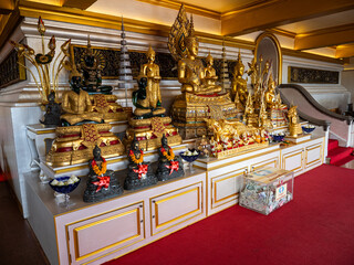 Black and golden Buddha statues staggered on a fundament in Wat Saket, Golden Mount, Bangkok, Thailand