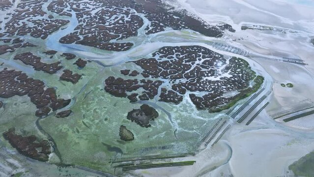 Natural pattern in salt pans and marsh in Fuseta in the district of Faro. Aerial view from a drone. Marshes and salt flats of the Ria Formosa Natural Park. Atlantic Ocean. Algarve. Portugal. Europe