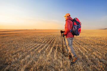 Naklejka na ściany i meble Man traveling with backpack hiking in countryside. active healthy lifestyle adventure journey vacations eco tourism.