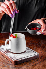 woman hand decorated chocolate fondant cake with ice cream and caramel