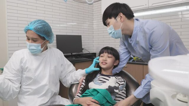Happy female dentist with patient girl at clinic.Asian children's dentistry for healthy teeth and beautiful smile .