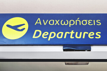 Close-up of the sign on the Mykonos airport meaning ''departures'', written in both Greek and English
