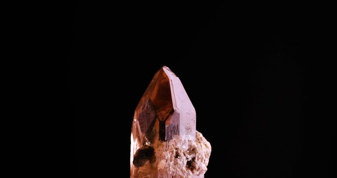 imperial topaz crystal rotating light 4k. macro detail texture background. close-up raw rough unpolished semi-precious gemstone 