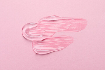 Swatches of cosmetic gel on pink background, top view