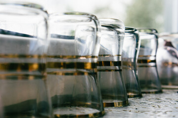 Close-up empty retro vintage glasses on wooden board with different reflections and glitter