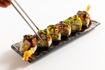 Grilled salmon sushi Nigiri with avocado on top. Japanese food isolated on white background