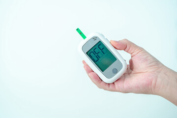 Close-up hand of pregnant woman show the checking her blood sugar level with glucometer and testing stripe at home, Gestational diabetes and pregnancy health, step 8