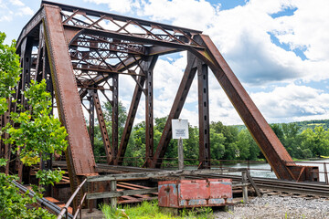 An old metal railroad bridge belonging to the Allegheny Railroad crossing the Allegheny River in Warren, Pennsylvania, USA on a sunny summer day