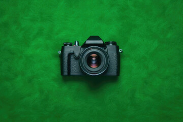 Top View of Sleek Black Camera on Vibrant Green Background