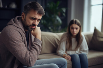 Relationship between father and child. Difficult conversation with teenager. Serious dad and sad daughter sitting on sofa and talking. Family problems - obrazy, fototapety, plakaty