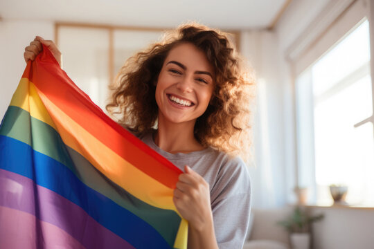 Smiling woman with rainbow flag. Happy female activist holding LGBT flag.