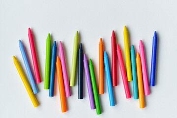 Bright colorful generic crayons on blank white paper - back to school background concept