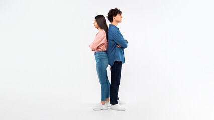 Unhappy Young Couple Crossing Hands Standing Back To Back, Studio