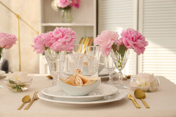 Stylish table setting with beautiful peonies and fabric napkin indoors