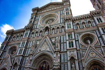 Fototapeta premium The grand entrance of the Florence Cathedral captivates with its intricate marble work and majestic rose window, a breathtaking example of Gothic and Renaissance fusion.