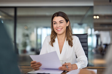 Smiling mature business woman hr holding cv at job interview. Happy mid aged professional banking financial manager, insurance agent, lawyer consulting clients sitting at work corporate office meeting - obrazy, fototapety, plakaty