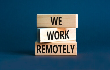 We work remotely symbol. Concept words We work remotely on wooden block. Beautiful grey table grey background. Business we work remotely concept. Copy space.