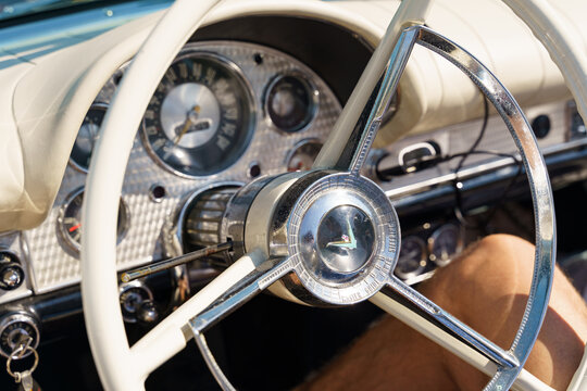 White Ford Thunderbird steering wheel, car dashboard in the background.