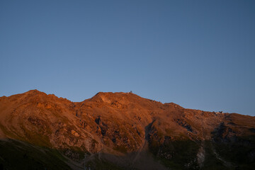 une montagne rouge au lever du soleil avec un ciel bleu intense
